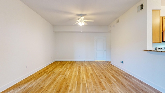 spare room with ceiling fan and light wood-type flooring