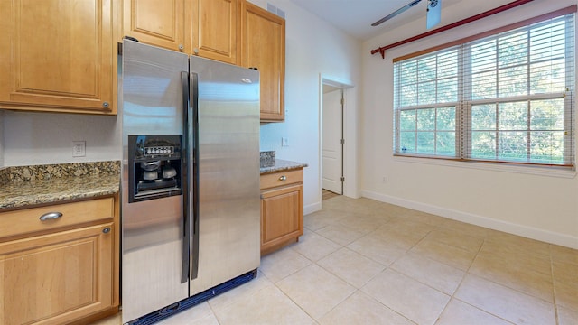 kitchen with light tile patterned floors, ceiling fan, stone counters, and stainless steel refrigerator with ice dispenser