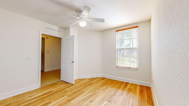 spare room featuring ceiling fan, hardwood / wood-style floors, and a textured ceiling