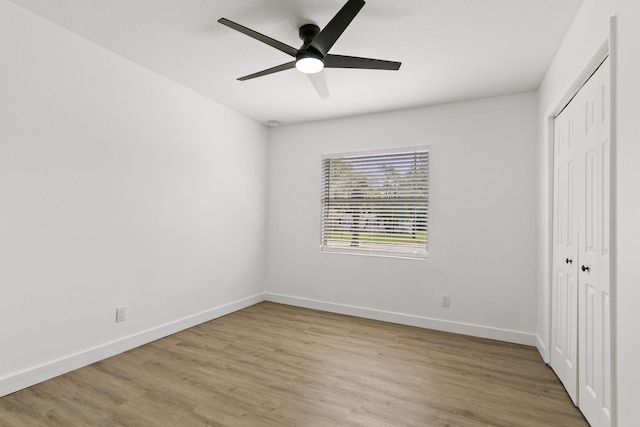 unfurnished bedroom featuring ceiling fan, a closet, and light hardwood / wood-style flooring