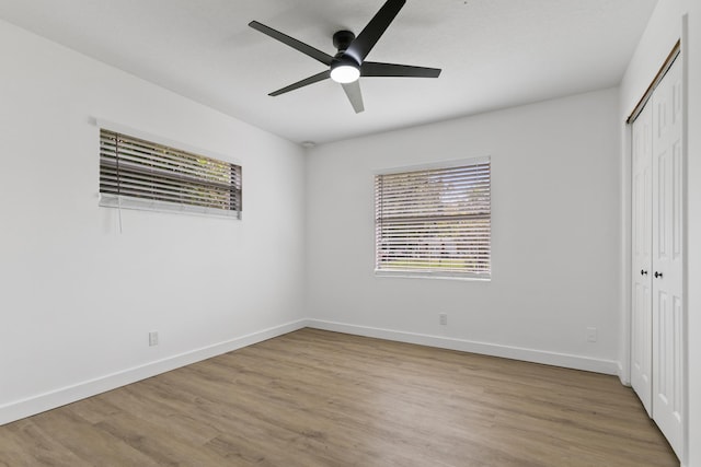 unfurnished bedroom with ceiling fan, a closet, and light wood-type flooring