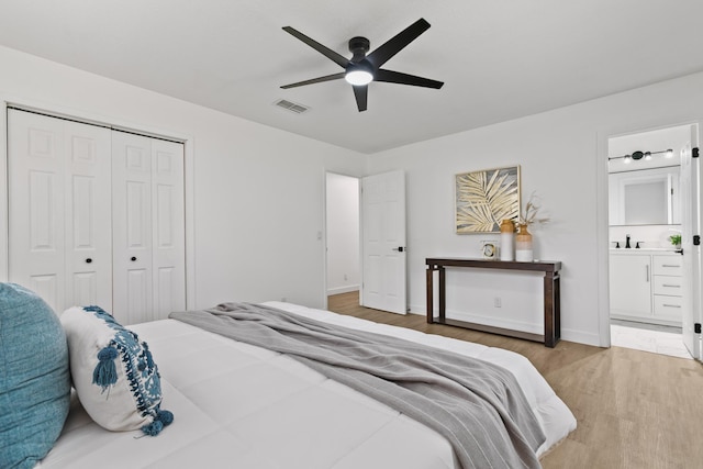 bedroom featuring a closet, ensuite bath, ceiling fan, and hardwood / wood-style flooring