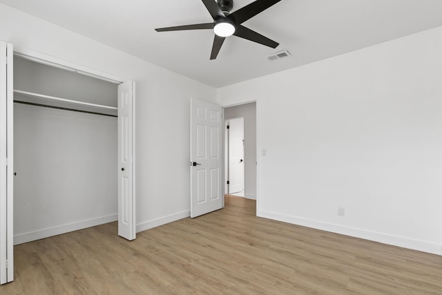 unfurnished bedroom featuring a closet, light hardwood / wood-style flooring, and ceiling fan