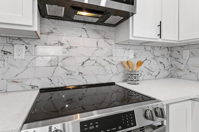 kitchen featuring decorative backsplash, stove, and white cabinetry