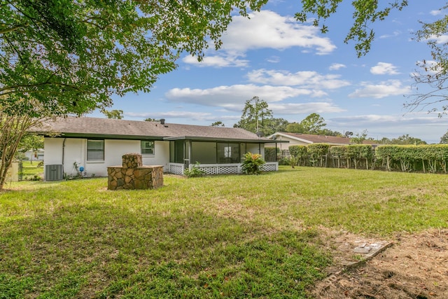 rear view of house featuring a lawn, a sunroom, and cooling unit