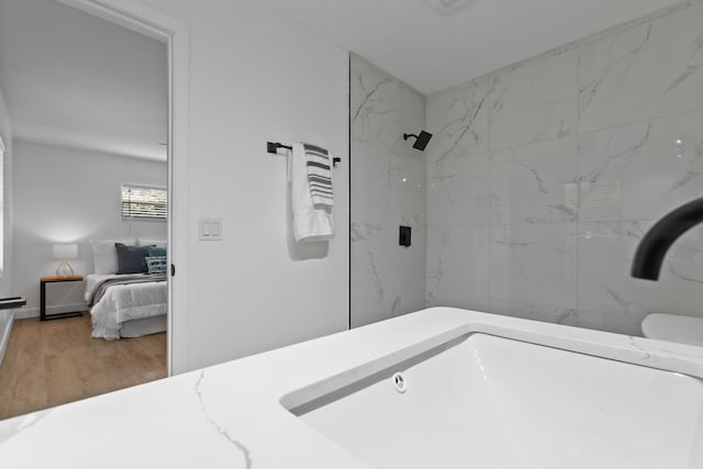 bathroom featuring a tile shower and hardwood / wood-style flooring