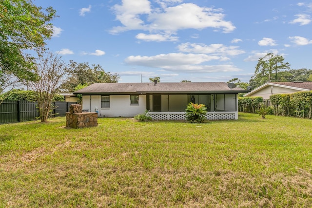 rear view of property with a lawn and a sunroom