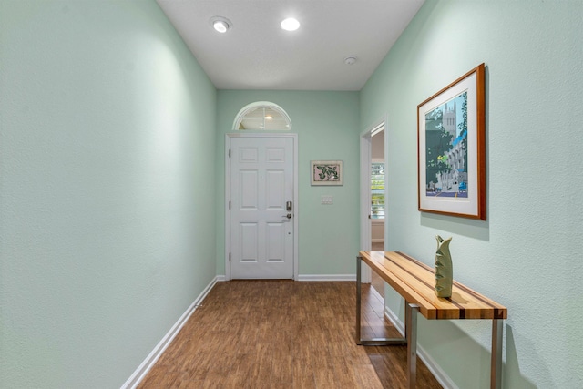 doorway with dark wood finished floors and baseboards