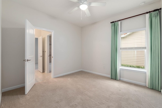 spare room with carpet flooring, a ceiling fan, and baseboards