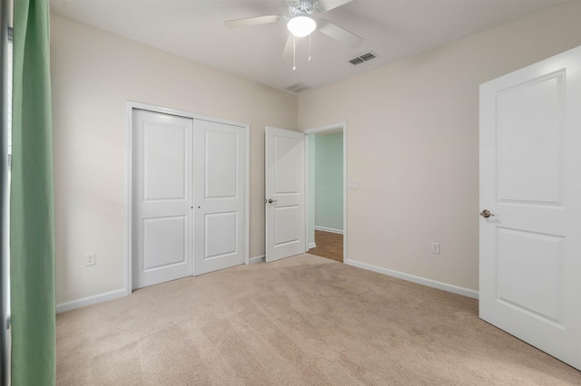 unfurnished bedroom with carpet floors, a ceiling fan, visible vents, baseboards, and a closet