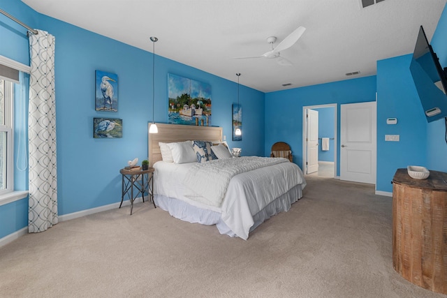 carpeted bedroom featuring a ceiling fan, multiple windows, visible vents, and baseboards