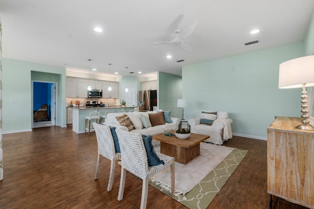 living room featuring recessed lighting, dark wood-style flooring, visible vents, and ceiling fan