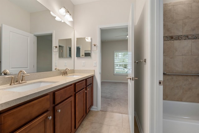 bathroom featuring double vanity, a sink, a bathing tub, and tile patterned floors