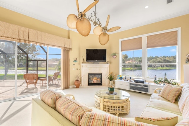 carpeted living room with a wealth of natural light, ornamental molding, and ceiling fan