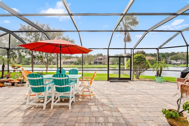 view of patio / terrace featuring glass enclosure and a water view