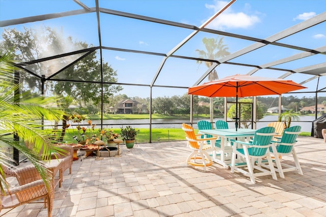 view of patio / terrace featuring a lanai and a water view