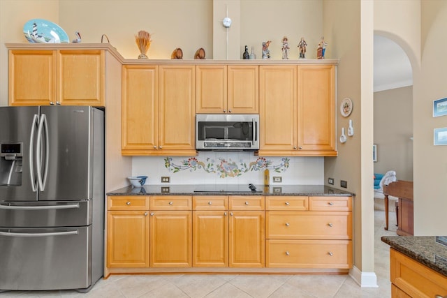 kitchen with decorative backsplash, dark stone counters, stainless steel appliances, crown molding, and light tile patterned floors