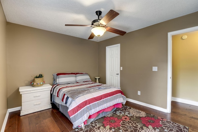 bedroom featuring ceiling fan, dark hardwood / wood-style flooring, and a textured ceiling