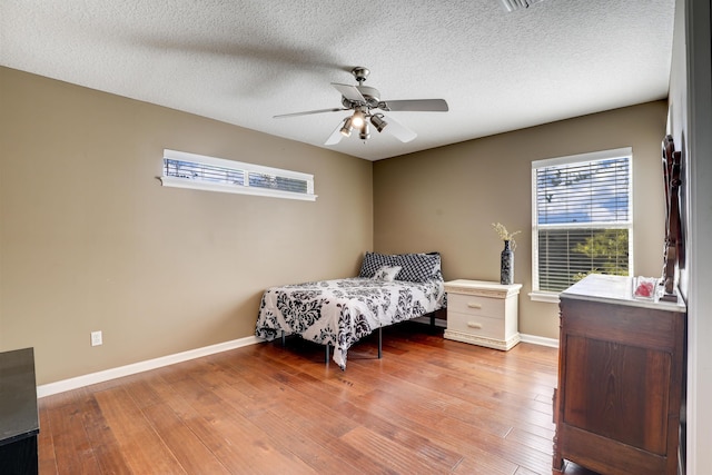 bedroom featuring a textured ceiling, light hardwood / wood-style floors, and ceiling fan