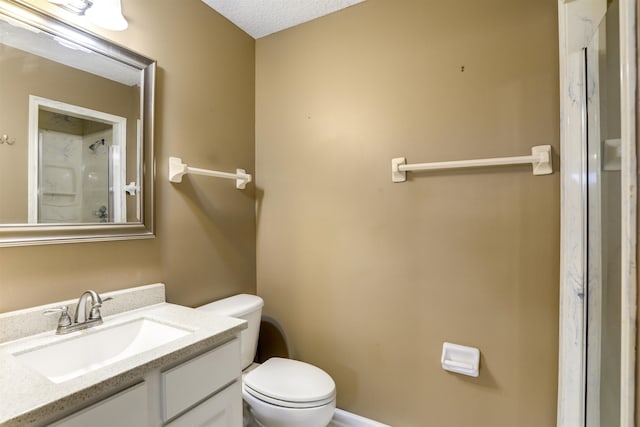 bathroom featuring vanity, a textured ceiling, and toilet