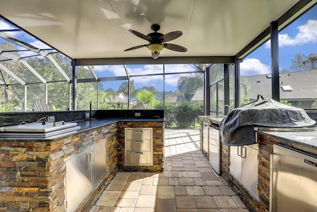 view of patio / terrace with an outdoor kitchen, ceiling fan, and a lanai