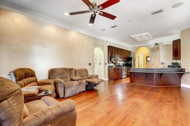 living room with light wood-type flooring and crown molding