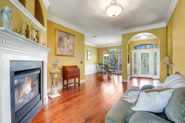 living room featuring a fireplace, ornamental molding, and hardwood / wood-style flooring