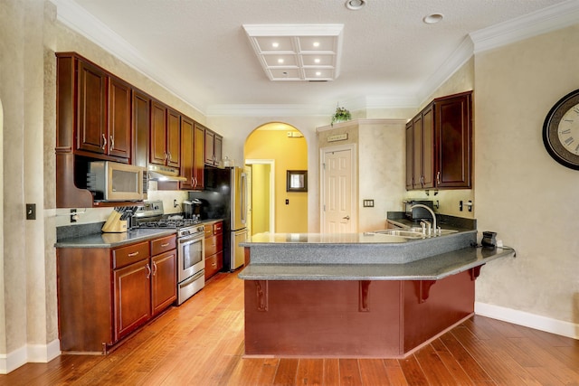 kitchen featuring a kitchen bar, appliances with stainless steel finishes, light hardwood / wood-style floors, and sink