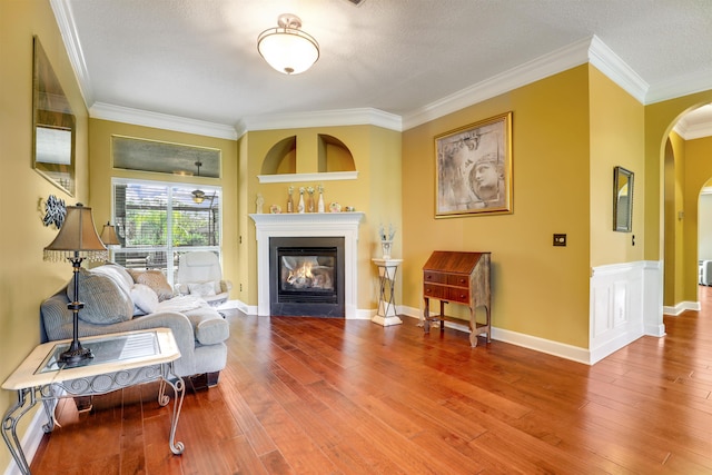 sitting room with a textured ceiling, hardwood / wood-style flooring, and ornamental molding