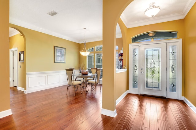 entryway featuring hardwood / wood-style floors, plenty of natural light, and ornamental molding