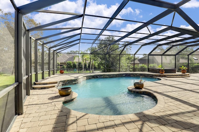 view of swimming pool featuring glass enclosure and a patio