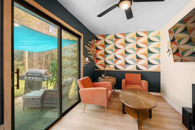 living area with light hardwood / wood-style floors and ceiling fan