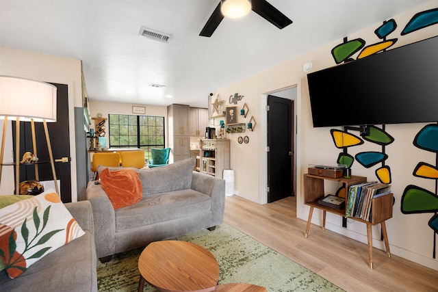 living room featuring ceiling fan and light wood-type flooring