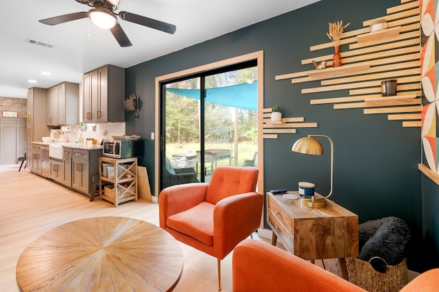 sitting room featuring light hardwood / wood-style floors, ceiling fan, and sink