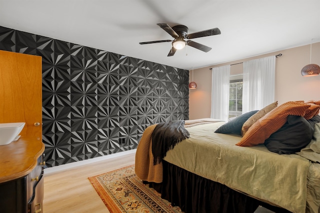 bedroom featuring hardwood / wood-style flooring, ceiling fan, and sink