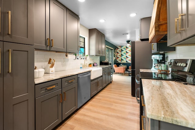 kitchen featuring ceiling fan, light stone counters, stainless steel dishwasher, light hardwood / wood-style floors, and gray cabinets