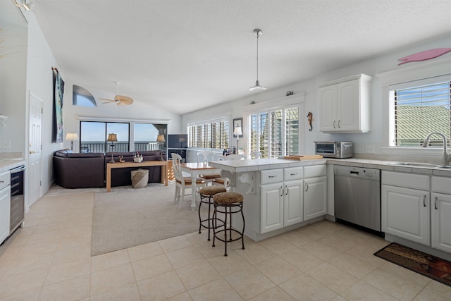 kitchen with white cabinets, stainless steel dishwasher, a healthy amount of sunlight, and sink