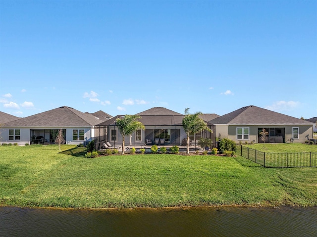 back of property featuring a water view, a yard, and glass enclosure