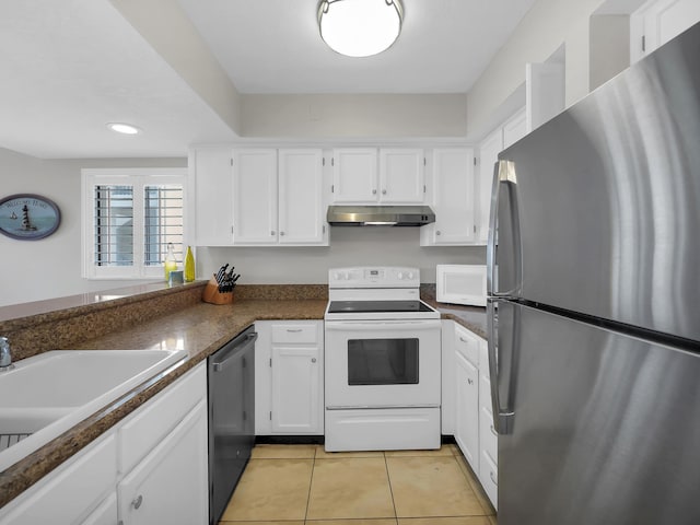 850 A1A Beach Blvd Unit 42, Saint Augustine Beach, FL 32080 - kitchen with appliances with stainless steel finishes, under cabinet range hood, white cabinetry, light tile patterned flooring, and recessed lighting