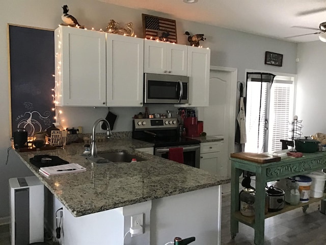 kitchen featuring kitchen peninsula, white cabinetry, sink, and stainless steel appliances