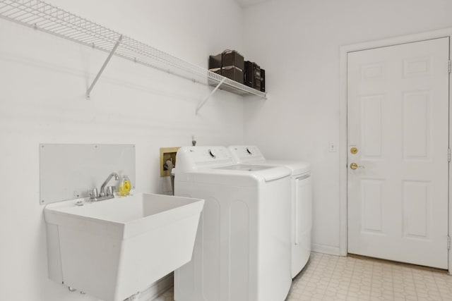 laundry area featuring a sink, washing machine and clothes dryer, laundry area, and light floors