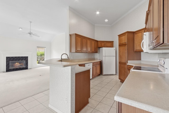 kitchen featuring white appliances, brown cabinetry, a peninsula, light tile patterned flooring, and crown molding
