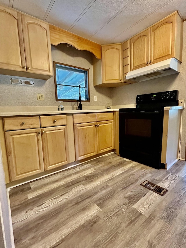 kitchen with visible vents, light brown cabinetry, under cabinet range hood, black / electric stove, and light wood finished floors