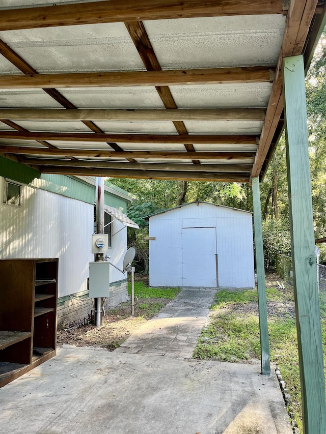 view of parking with a storage unit and a carport