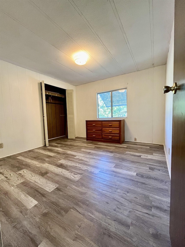 unfurnished bedroom with a textured ceiling and wood finished floors