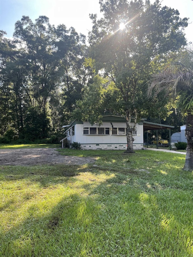 view of front of property featuring an attached carport, a front yard, driveway, and crawl space