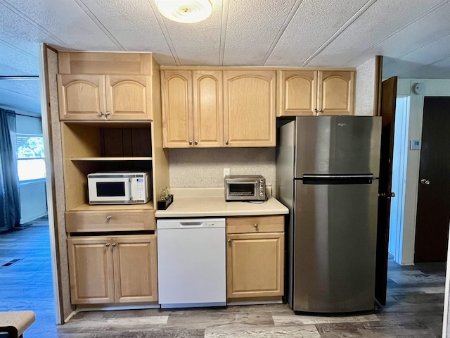 kitchen featuring light brown cabinets, a toaster, light wood-type flooring, light countertops, and white appliances