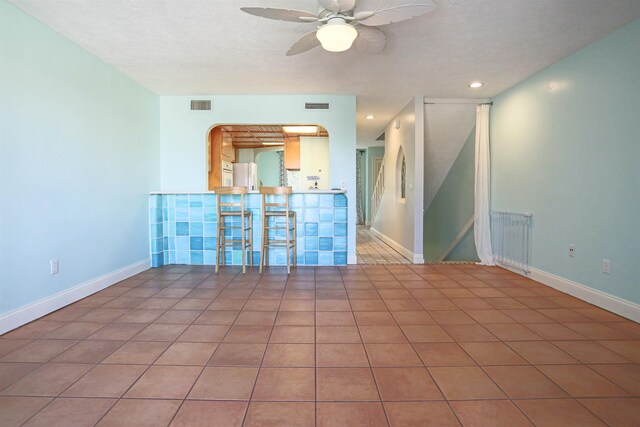 unfurnished room featuring tile patterned flooring, radiator, and ceiling fan