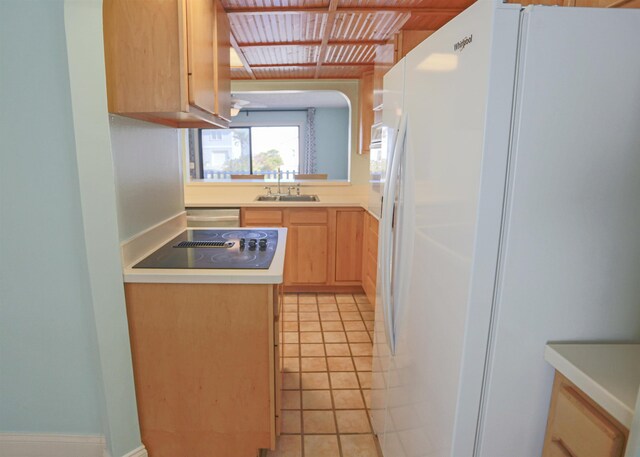 kitchen with light brown cabinetry, black electric cooktop, sink, white refrigerator with ice dispenser, and light tile patterned floors