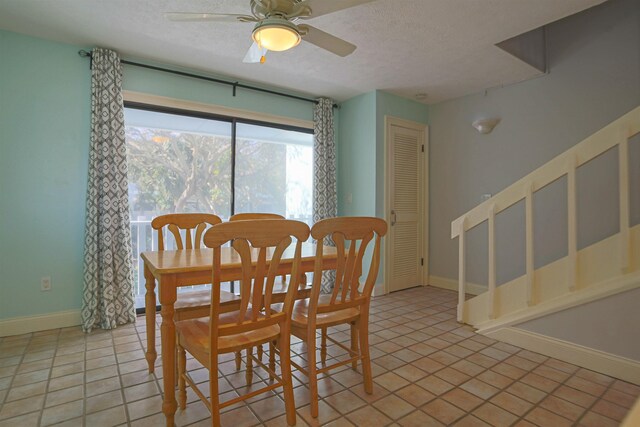 tiled dining room featuring a textured ceiling and ceiling fan